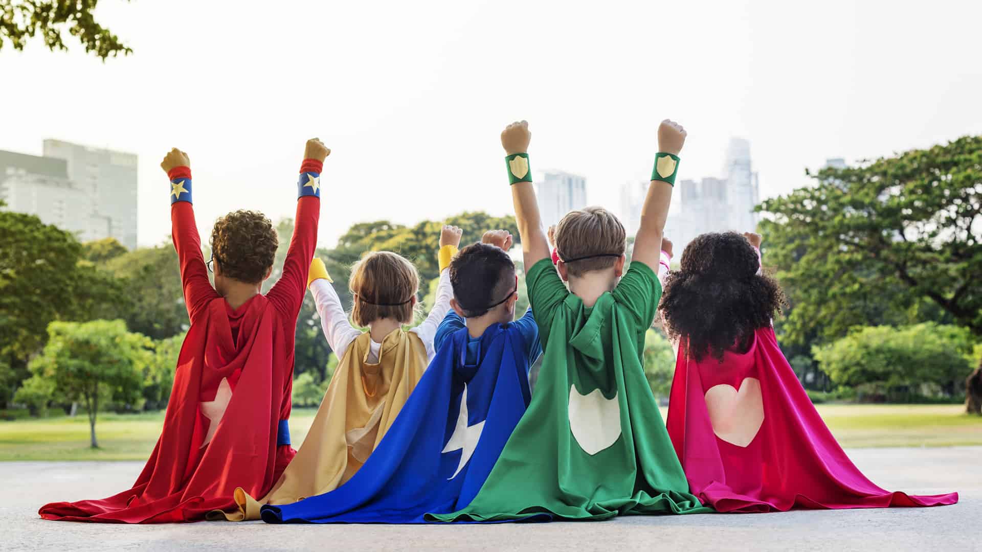Children with colorful capes and hands up, image of sponsorship section.