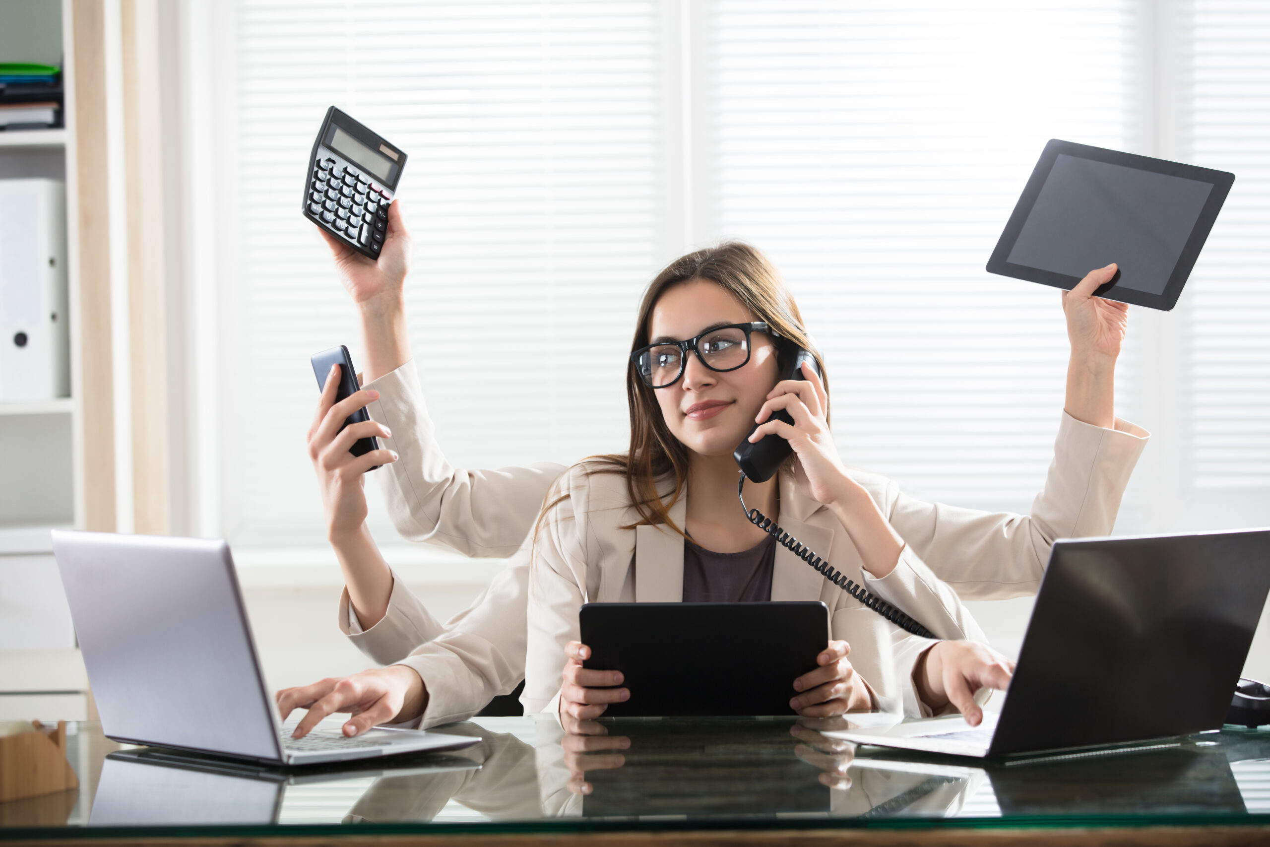 Woman holding electronics while talking on the phone, image of new podcast episode about relieving anxiety and breaking from busyness with Judson Brewer MD, Ph.D. & Juliet Funta